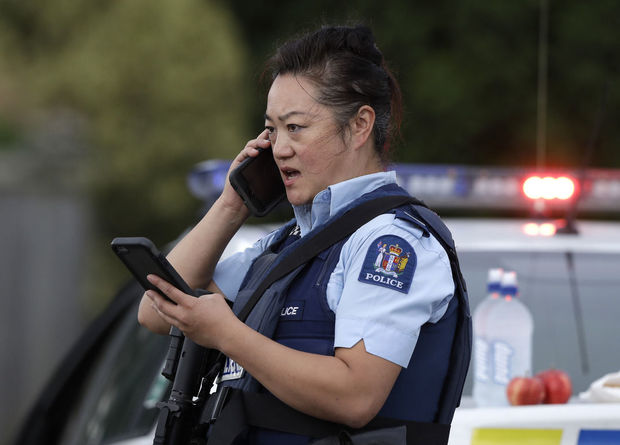 A police officer talks on her phone as a roadblock near a mass shooting at a mosque in Linwood, Christchurch, New Zealand, Friday, March 15, 2019. Multiple people were killed during shootings at two mosques full of people attending Friday prayers. (AP Photo/Mark Baker)