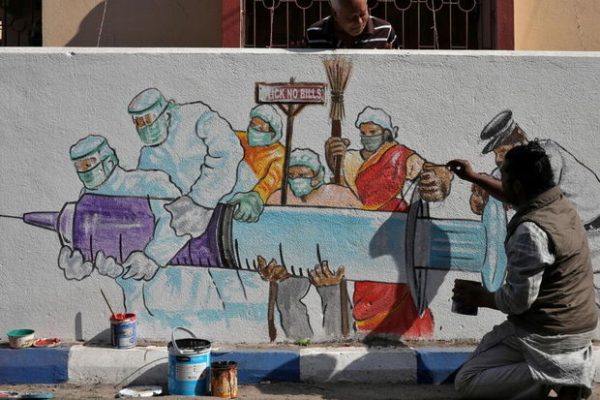 A man applies finishing touches to graffiti representing a vaccine, amidst the spread of coronavirus disease (COVID-19) in Kolkata, India, January 2, 2021. REUTERS/Rupak De Chowdhuri NO ARCHIVES. NO RESALES.