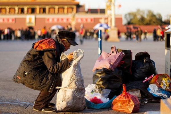 A man collects waste bottles at Tiananmen Square in central Beijing, December 4, 2013. Picture taken December 4, 2013. REUTERS/Stringer (CHINA - Tags: SOCIETY POVERTY) - GM1E9C50W3T01